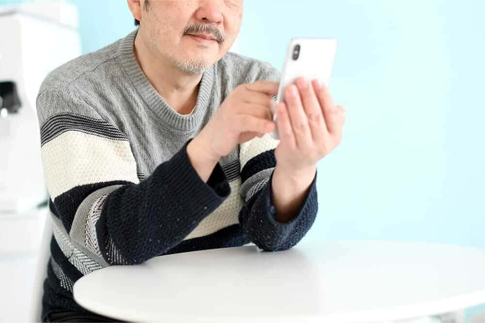 写真：スマホを持つ男性